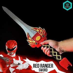 Op de afbeelding: Een rood en zilver zwaard met een decoratieve handgreep, tegen een zwarte achtergrond. De handgreep heeft gouden en groene accenten. De tekst "RED RANGER SWORD" staat eronder.