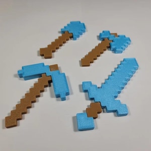 May include: Four Minecraft-themed tools made of plastic. A blue pickaxe, a blue sword, a blue shovel, and a blue axe. Each tool has a brown wooden handle.