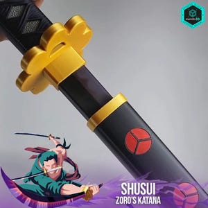 May include: A close-up of a black and gold katana sword with a red emblem. The sword features a gold guard and accents, with the text "SHUSUI ZORO'S KATANA" at the bottom. The sword is held in a hand.