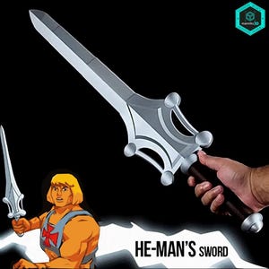 May include: A silver-colored sword with a dark handle and a distinctively shaped guard featuring four rounded protrusions. The sword is held in a hand, and the image includes a graphic of a cartoon character holding a similar sword and the text HE-MAN'S SWORD.