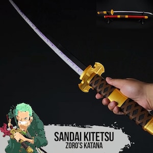 May include: A gold and brown katana with a purple blade is held in a hand. The handle has a diamond pattern. The text "SANDAI KITETSU ZORO'S KATANA" is at the bottom. Two other katanas are displayed in the background.