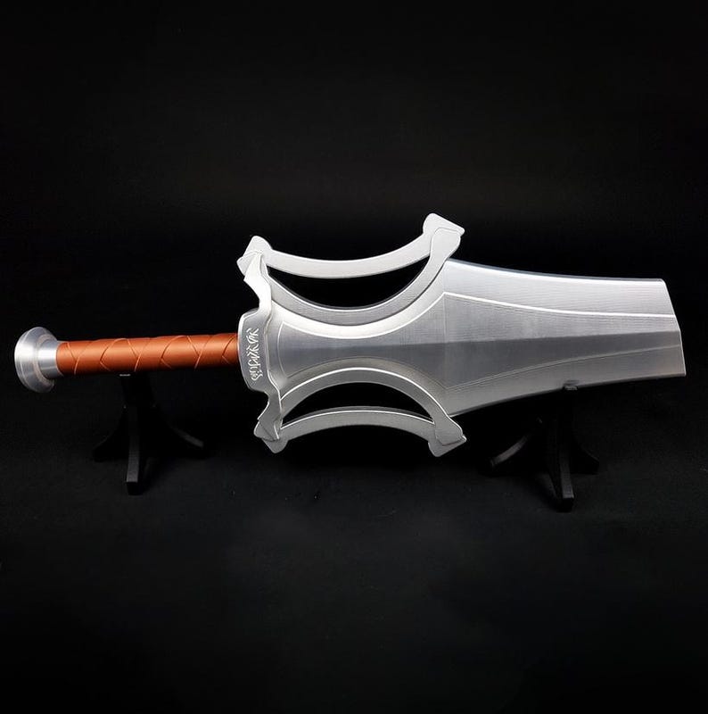 May include: A silver-colored sword with a wide, flat blade and a complex, open-work crossguard. The handle is wrapped in a textured, copper-colored material, and the pommel is a simple silver disc. The sword is displayed horizontally.