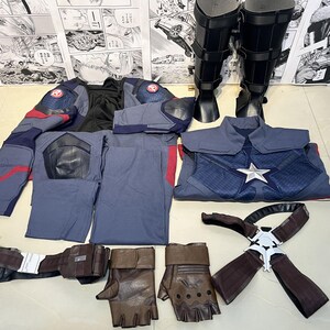 May include: A Captain America costume set with a blue and red jacket, pants, and a chest piece with a star. The set also includes a pair of brown leather gloves, a black belt with a silver buckle, and a pair of black boots.