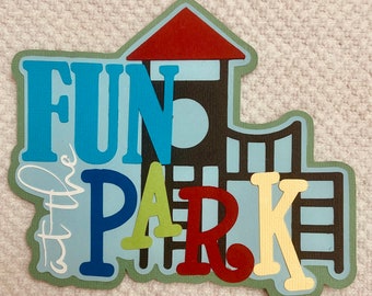 May include: A layered paper cutout in the shape of a playground with the words "FUN PARK" in blue, green, red, and yellow. The phrase "the" is written in white script. The playground structure is brown with a red roof.