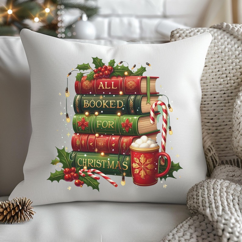 May include: White decorative pillow featuring a stack of books with the words "ALL BOOKED FOR CHRISTMAS." The books are red and green with holly and berry accents. A red mug with a snowflake design and candy canes complete the festive design.