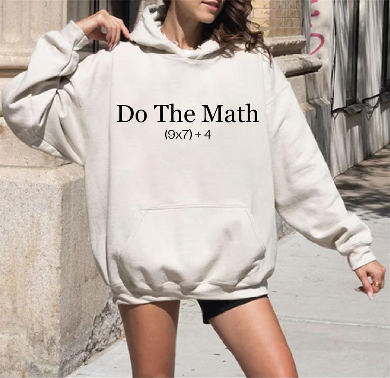A person wearing a white hoodie with the text "Do The Math [9x7+4]" printed on it.