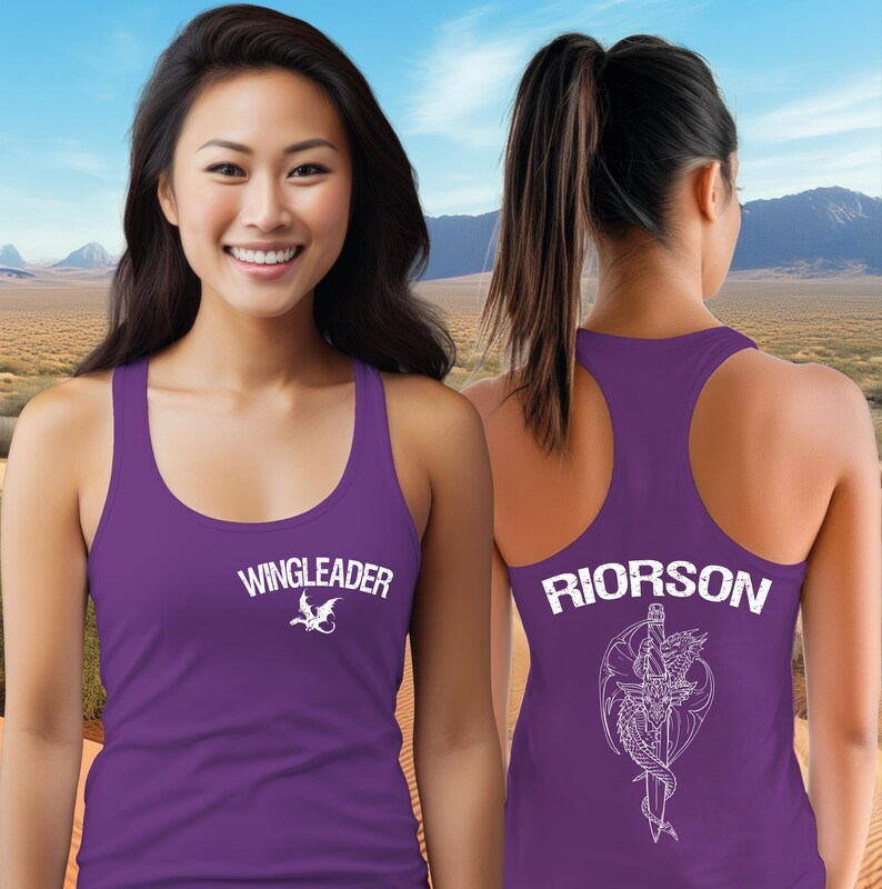 A woman wearing a purple tank top with the text "WINGLEADER" and a dragon design on the front, standing in front of a desert landscape with mountains in the background.