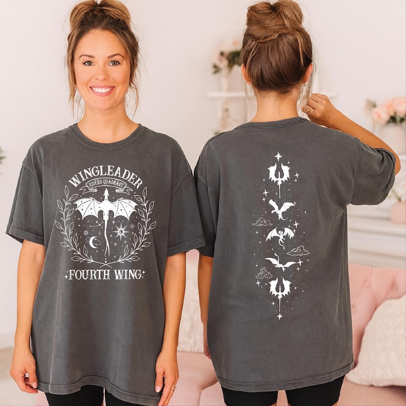 A woman wearing a grey t-shirt with a graphic design on the front and back.