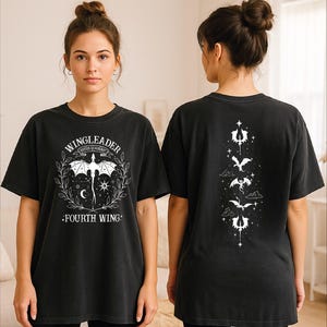 A woman wearing a black t-shirt with a graphic design on the front and back.