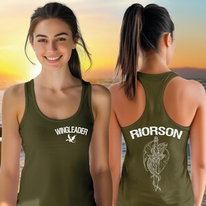 A woman wearing a green tank top with the text "WINGLEADER" printed on it, smiling at the camera.