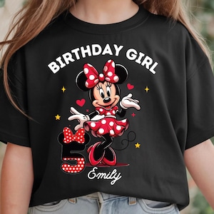 A young girl wearing a black t-shirt with a Minnie Mouse design and the text "Birthday Girl Emily" printed on it.