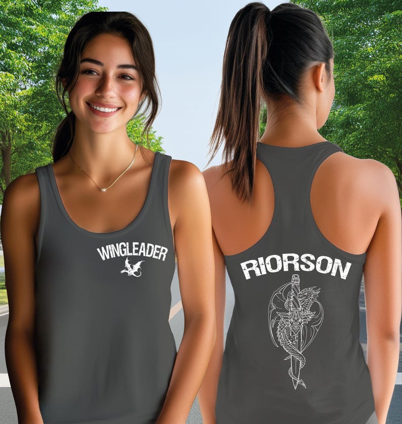 A woman wearing a grey tank top with the text "WINGLEADER" and "RIORSON" printed on it, smiling at the camera.