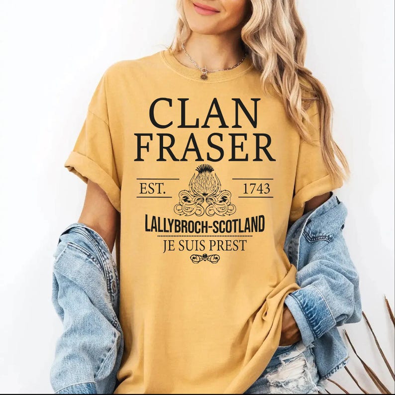 A woman wearing a yellow t-shirt with text and graphics printed on it.
