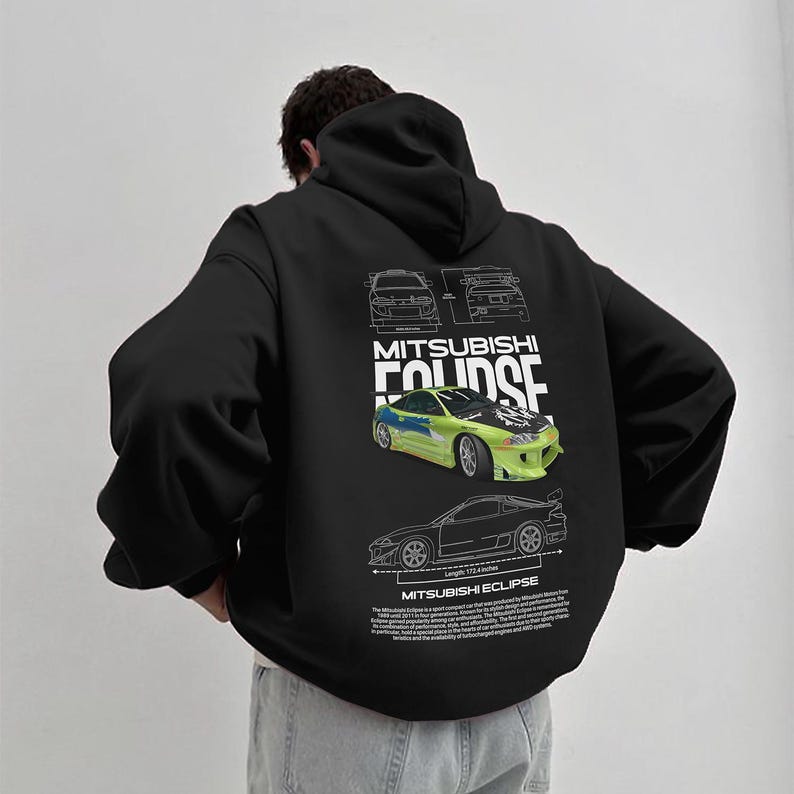 May include: Black hooded sweatshirt featuring a graphic of a Mitsubishi Eclipse car in green and yellow. The design includes car schematics and the text "MITSUBISHI ECLIPSE". The sweatshirt has a relaxed fit and a drawstring hood.