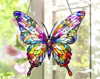 May include: A butterfly-shaped suncatcher featuring a multi-colored stained glass design with intricate black outlines. The wings display a vibrant mosaic of purple, blue, yellow, orange, and red segments. It hangs from two thin black metal chains.