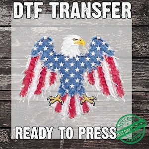 May include: DTF TRANSFER ready to press. A patriotic design featuring an eagle with wings spread, incorporating the American flag's colors and stars. The eagle's body is white, with a yellow beak and talons. The wings are blue with white stars and red and white stripes.