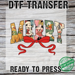 May include: DTF TRANSFER graphic featuring the word "MERRY" with Disney characters in festive attire. A large red bow is beneath the word. The text "READY TO PRESS" is below the bow, with a "NEXT DAY SHIPPING" stamp.