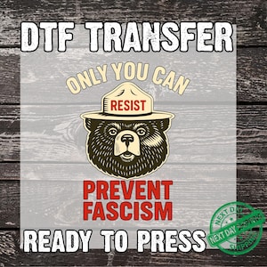 May include: DTF transfer graphic featuring a bear wearing a ranger hat with the word "RESIST". The text "ONLY YOU CAN" is above the bear, and "PREVENT FASCISM" is below. The words "READY TO PRESS" are at the bottom.