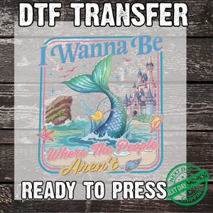 May include: DTF transfer featuring a mermaid with a teal tail, seashell, and a castle. The text "I Wanna Be Where The People Aren't" is displayed in a retro font. The words "READY TO PRESS" are also visible.