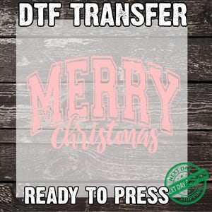 May include: A pink "Merry Christmas" DTF transfer, ready to press. The design features the words "Merry Christmas" in a bold, outlined font. The words "DTF TRANSFER" and "READY TO PRESS" are also in the image.