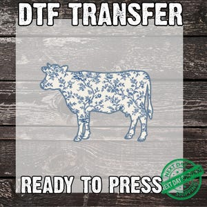 May include: A DTF transfer featuring a cow silhouette with a blue floral pattern. The text "DTF TRANSFER" is at the top, and "READY TO PRESS" is at the bottom. A green "NEXT DAY SHIPPING" stamp is in the lower right corner.
