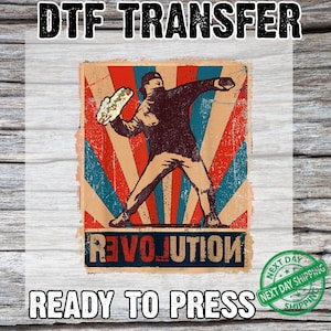 May include: DTF TRANSFER ready to press. A vintage-style graphic features a figure throwing a taco against a red, blue, and tan burst background. The word "REVOLUTION" is at the bottom. The image is on a white background.