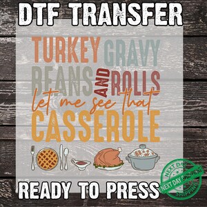 May include: DTF transfer with text "TURKEY GRAVY BEANS AND ROLLS Let me see that CASSEROLE" and illustrations of Thanksgiving food. Includes a pie, gravy, turkey, and casserole. The words "READY TO PRESS" are also included.