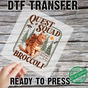 May include: DTF transfer featuring a cartoon cat with a backpack, the words "Quest Squad Broccoli", and the text "No One Wants It, But It's Good For You". The transfer is ready to press.