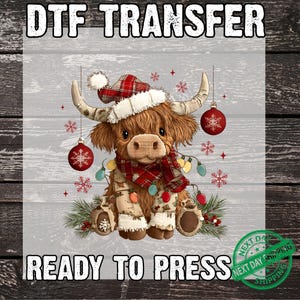 以下が含まれることがあります： DTF TRANSFER プレスする準備ができました。サンタ帽、スカーフ、お祝いのライトを身に着けたハイランド牛の気まぐれなイラスト。赤いオーナメントと雪の結晶がクリスマスのテーマを加えています。牛は茶色です。