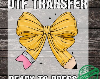 May include: A DTF transfer design featuring a yellow bow and a pencil. The bow is drawn with pencil-like lines, and the pencil has a pink eraser and a black tip. The text "DTF TRANSFER" and "READY TO PRESS" are at the top and bottom.