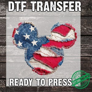 May include: DTF transfer featuring a Mickey Mouse head design in red, white, and blue patchwork, with white stars on the blue section. The text "DTF TRANSFER" and "READY TO PRESS" are displayed above and below the design.