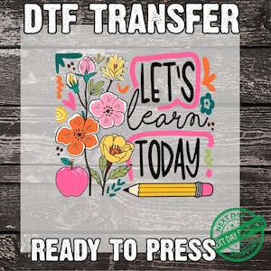May include: DTF transfer with the text "LET'S learn TODAY" in black script, surrounded by a pink frame. The design includes colorful flowers, an apple, and a pencil. The words "READY TO PRESS" are at the bottom.
