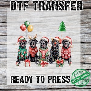 May include: DTF TRANSFER image featuring five black Labrador Retrievers wearing Christmas sweaters and Santa hats. The dogs are surrounded by balloons, a Christmas tree, and wrapped gifts. The text "READY TO PRESS" is displayed below the dogs.