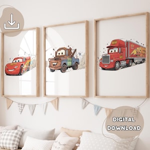 May include: Three framed prints featuring cartoon vehicles: a red race car, a rusty tow truck, and a red semi-truck. The prints are in wooden frames and are labeled "DIGITAL DOWNLOAD". The prints are displayed above a row of pillows and a decorative banner.