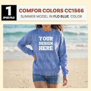 May include: A blue sweatshirt with the text "YOUR DESIGN HERE" in white. The sweatshirt is a summer model in a Flo Blue color. The image also includes the text "COMFOR COLORS CC1566".