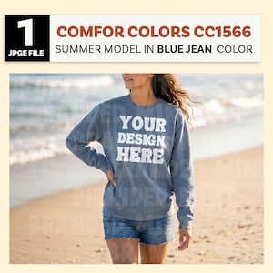 May include: A blue sweatshirt with the text "YOUR DESIGN HERE" in white. The model is wearing denim shorts. The image also contains the text "COMFOR COLORS CC1566 SUMMER MODEL IN BLUE JEAN COLOR".