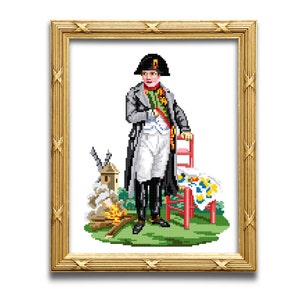 May include: A framed cross-stitch embroidery depicting a man in a black military uniform and a bicorne hat, standing next to a red chair and a small fire. The scene is set against a white background.