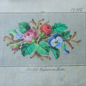 Może przedstawiać: Wzorzec haftu krzyżykowego z epoki przedstawiający bukiet kwiatów z różowymi różami, niebieskimi fiołkami i zielonymi liśćmi. Wzór znajduje się na kratkowanym tle z numerem 14 916 nadrukowanym w prawym górnym rogu. Tekst "Hortz & Wegener in Berlin" jest nadrukowany na dole wzoru.