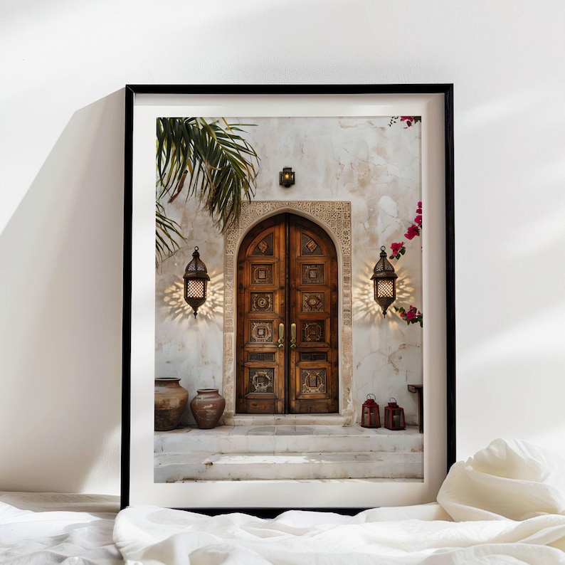 May include: A weathered wooden double door with intricate carvings, set in a white stucco wall with a palm tree and hanging lanterns. The door is framed by a stone archway and has a worn, rustic look.