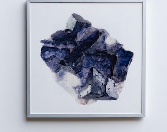 May include: A framed photograph of a large, purple and white crystal. The crystal has a rough, natural texture and is displayed against a white background.