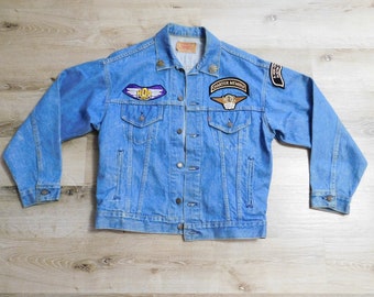 May include: A blue denim jacket with several patches, including a "HOG" patch, a "Charter Member" patch, and a "Harley Owners Group" patch.
