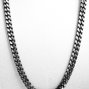 May include: A silver curb chain necklace with a classic design. The chain is made of metal and has a shiny finish.