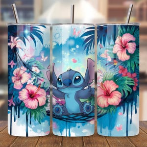 May include: A stainless steel tumbler featuring a blue cartoon character surrounded by pink hibiscus flowers, tropical leaves, and butterflies. The design has a watercolor effect with blue drips and a blue sky background. The tumbler includes a silver straw.