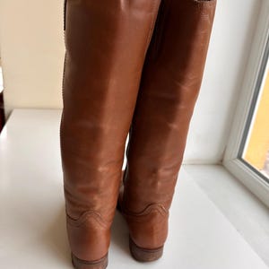Pu&ograve; includere: Un paio di stivali alti in pelle marrone. Gli stivali hanno un design classico con una finitura liscia e lucida. I tacchi sono bassi e le suole sono di un marrone pi&ugrave; scuro. Gli stivali sembrano essere in buone condizioni.