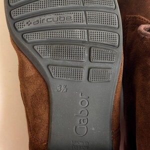 K&ouml;nnte beinhalten: Nahaufnahme der Sohle eines braunen Wildlederschuhs. Die dunkelgraue Sohle tr&auml;gt die Aufschrift "aircube" und "Gabor". Die Schuhgr&ouml;&szlig;e ist 3 1/2. Die Worte "Made in Portugal" sind ebenfalls zu sehen.