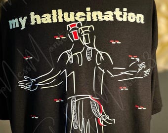 May include: Black t-shirt with the text "my hallucination" in white and light blue. A white line drawing of two figures with red accents is centered on the shirt. The text "Sign here: Danessa" is at the bottom.