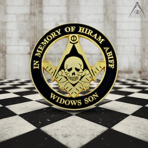 May include: A black and gold Masonic pin with the words "In Memory of Hiram Abiff Widows Son" around the edge. The centre of the pin features a skull and crossbones with a square and compass behind it.