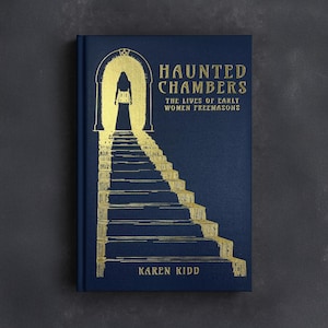 May include: Hardcover book titled "Haunted Chambers: The Lives of Early Women Freemasons" by Karen Kidd. The cover is navy blue with gold foil lettering and an illustration of a figure at the top of a staircase leading to an archway.