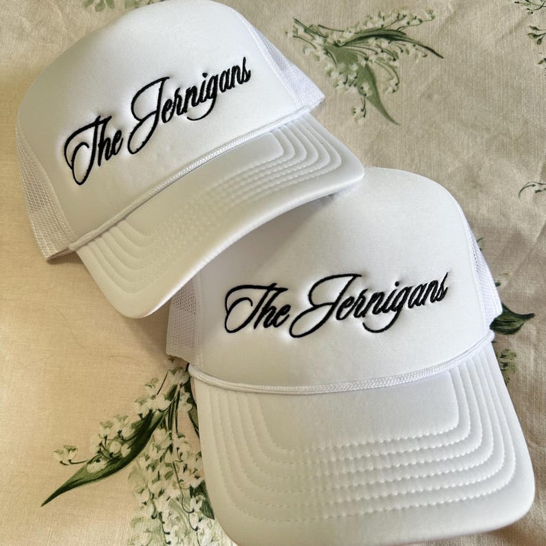 May include: Two white trucker hats with black embroidered text that reads "The Jernigans".