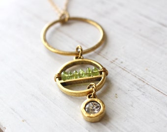 Long gold necklace with row of peridot and crystal drop